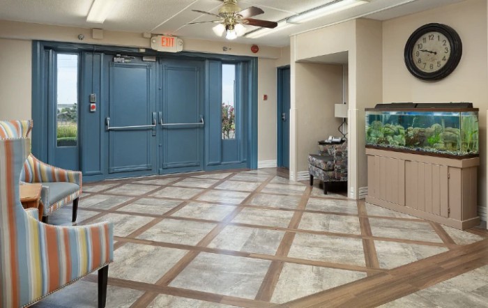 A spacious hallway with blue double doors and a fish tank.