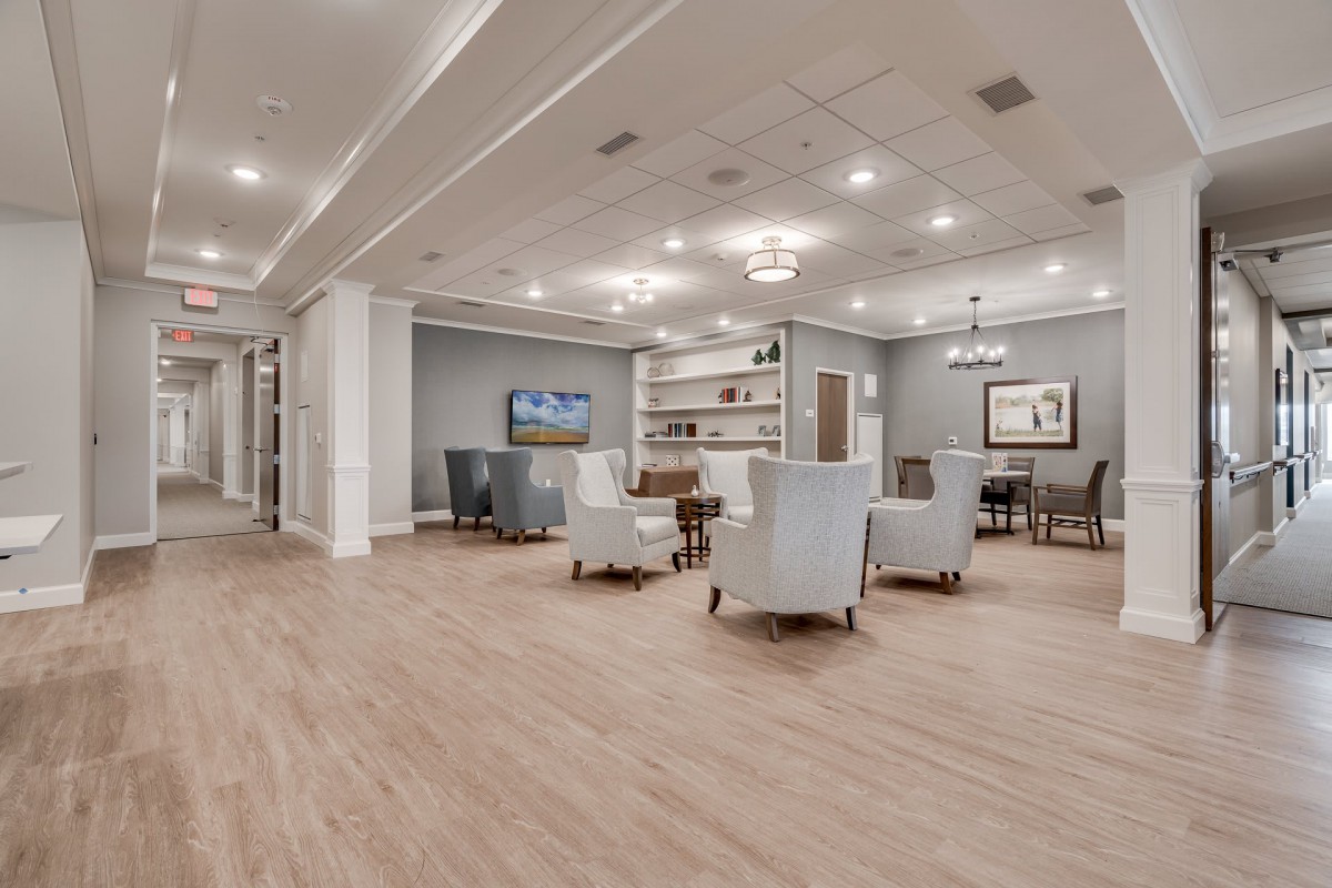 A modern lounge area with comfortable seating, a television, and elegant lighting.
