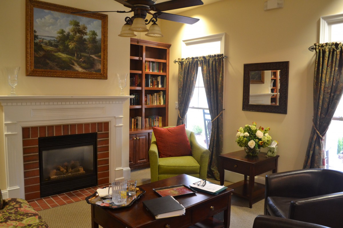 A cozy living room with a fireplace, bookshelves, and comfortable seating.