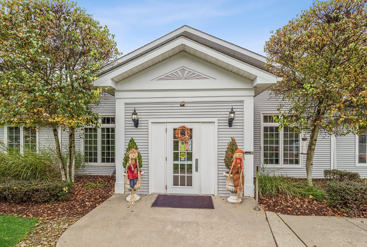 The front entrance of a white house with symmetrical design and neatly maintained landscaping.