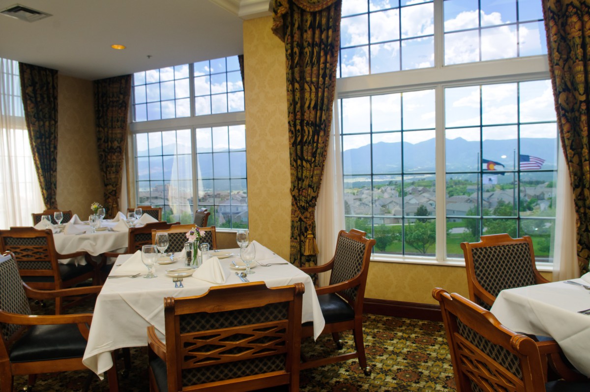 A cozy restaurant dining area with large windows offering a scenic mountain view.