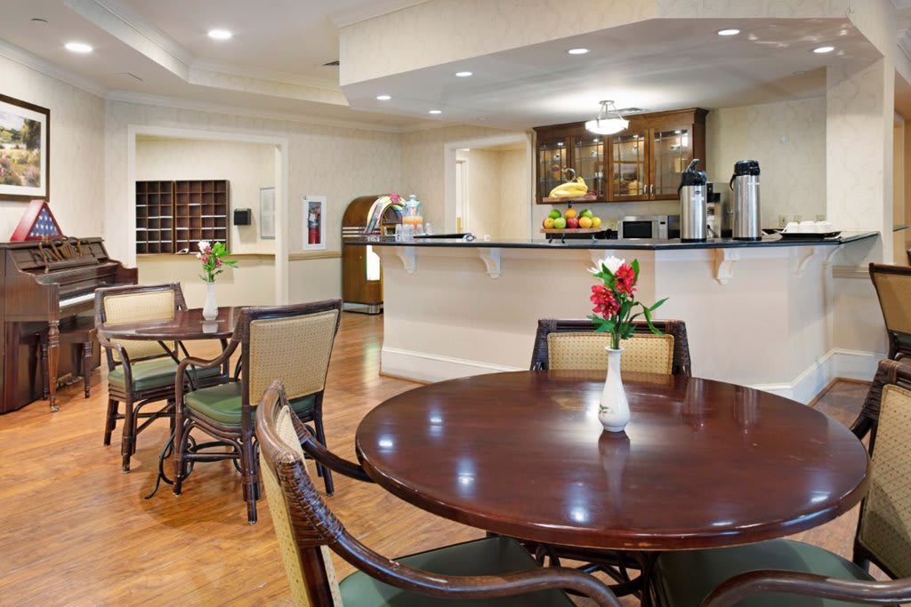 A cozy indoor dining area with tables and chairs, featuring a counter and coffee station.