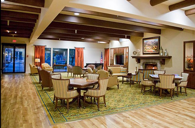 A cozy and well-decorated lounge area with comfortable seating, a fireplace, and large windows.