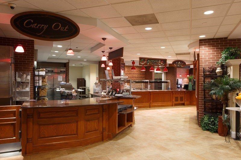 A spacious cafeteria with wooden counters and a variety of serving areas.