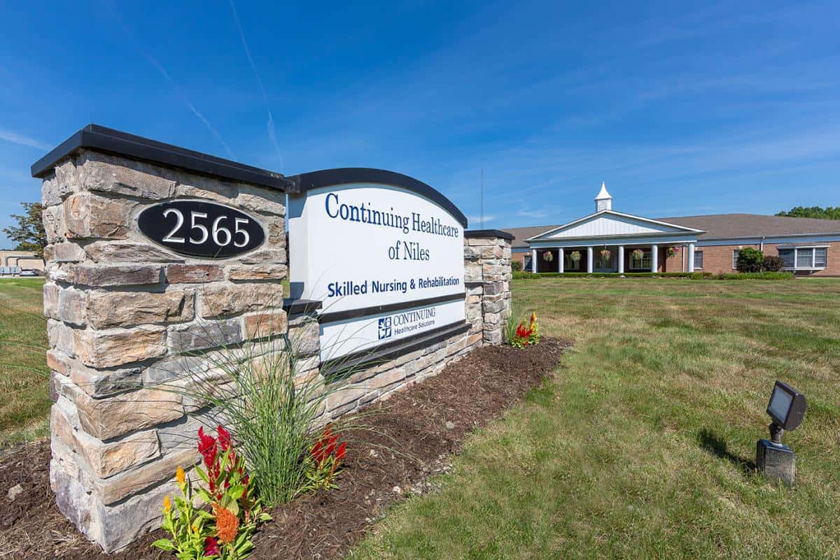 A healthcare facility with a prominent entrance sign and well-maintained landscaping.