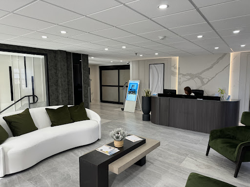 A modern office lobby featuring a stylish white sofa and a sleek reception desk.