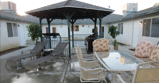 A cozy outdoor space featuring a gazebo, grill, and comfortable seating arrangements.