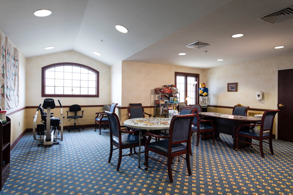 A well-lit conference room equipped with a variety of chairs and tables arranged for meetings.