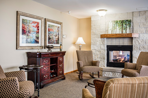 A cozy living room featuring a fireplace, comfortable seating, and decorative artwork.
