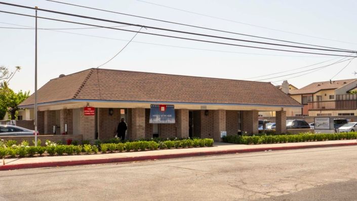 A commercial building with a brick facade located on a street under clear skies.