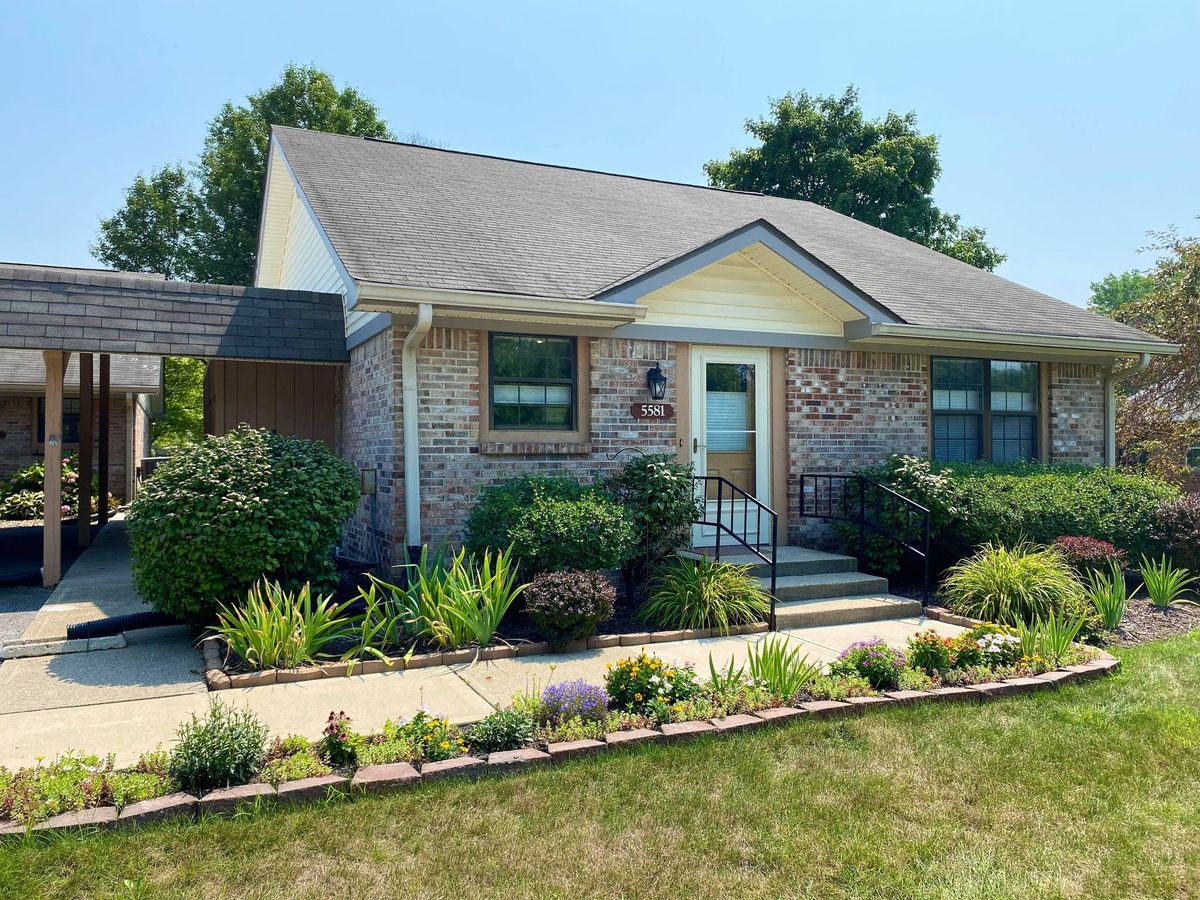 A charming suburban brick house with well-maintained landscaping.