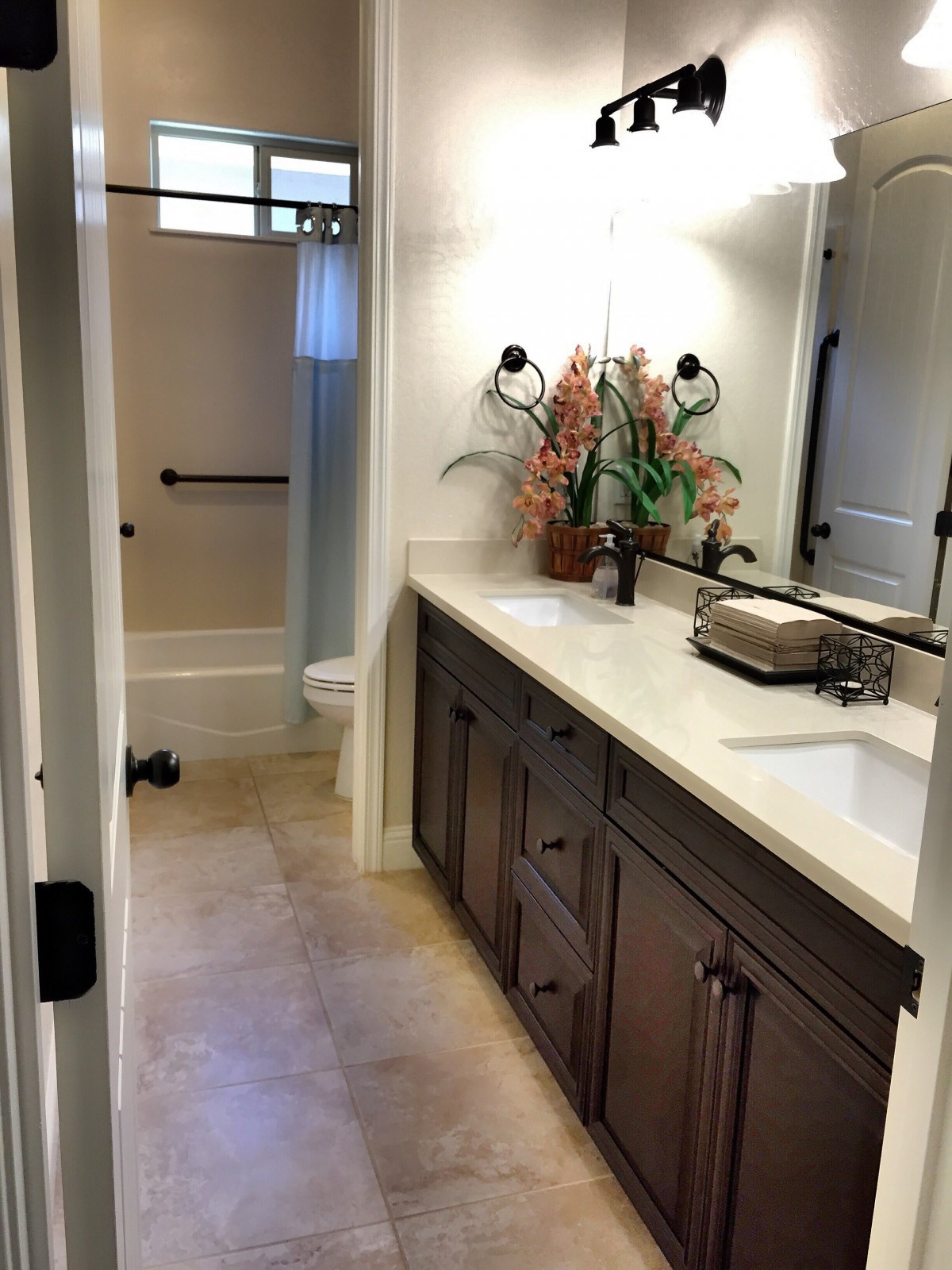 A modern bathroom featuring a double sink vanity and a spacious shower area.