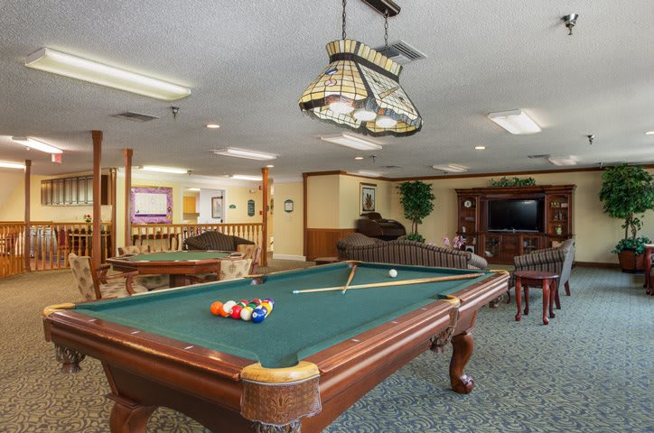A cozy game room featuring a pool table and comfortable seating.