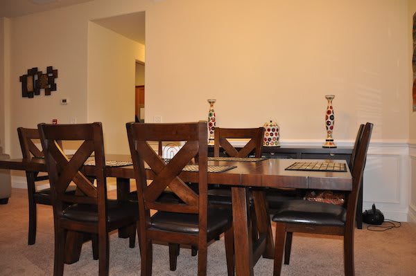 A dining room with a wooden table and chairs, adorned with decorative items.