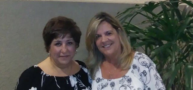 Two women posing together indoors.