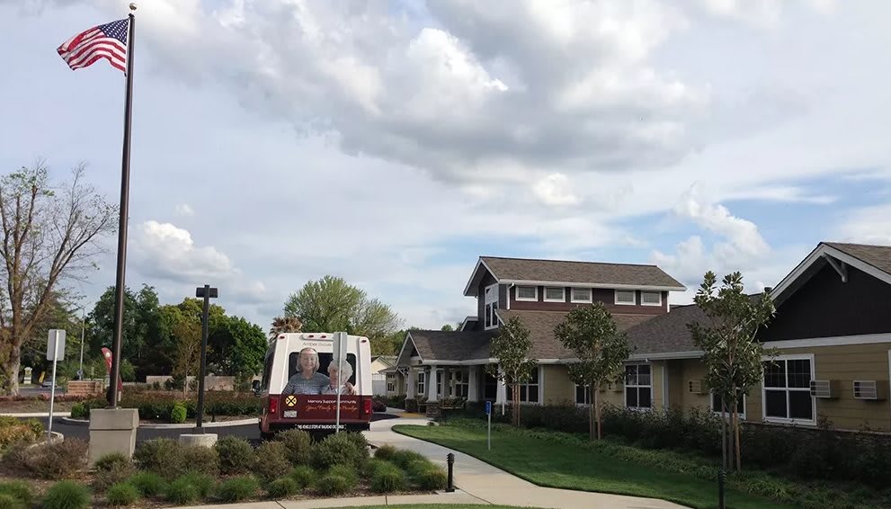 A fire truck parked outside a residential-style building under a cloudy sky.