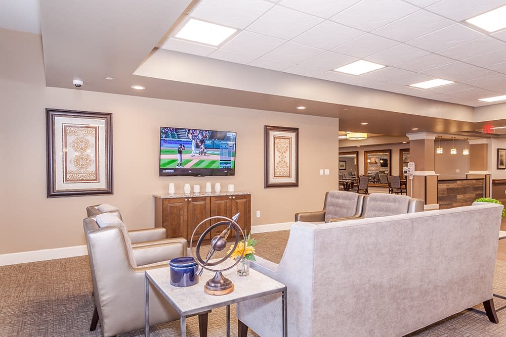 A modern living room with a comfortable seating area and a television on the wall.