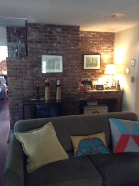 Cozy living room with a brick accent wall and stylish decorations.