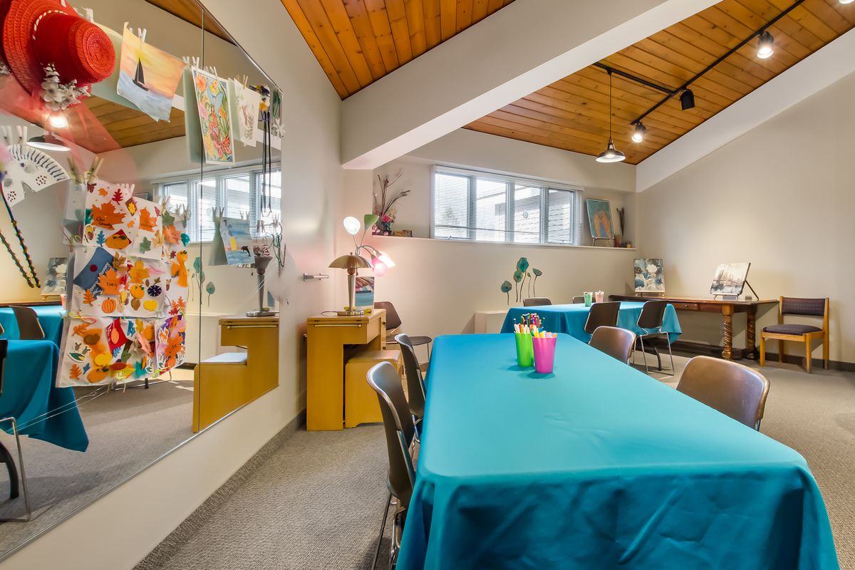 A colorful art classroom with tables and chairs set up for activities.