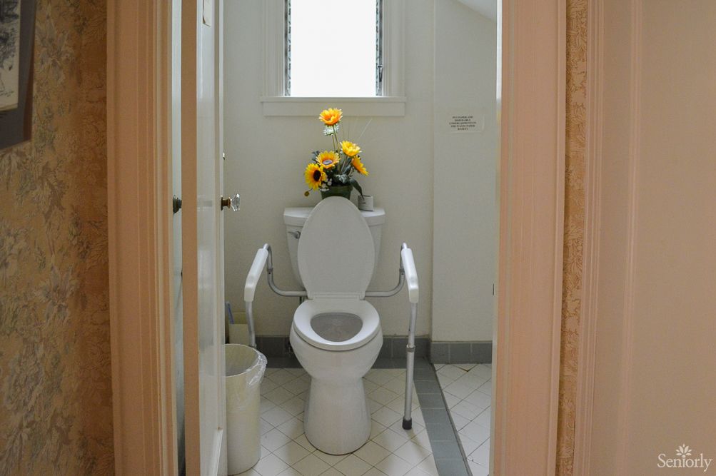 A small bathroom with a toilet and sunflower decoration.