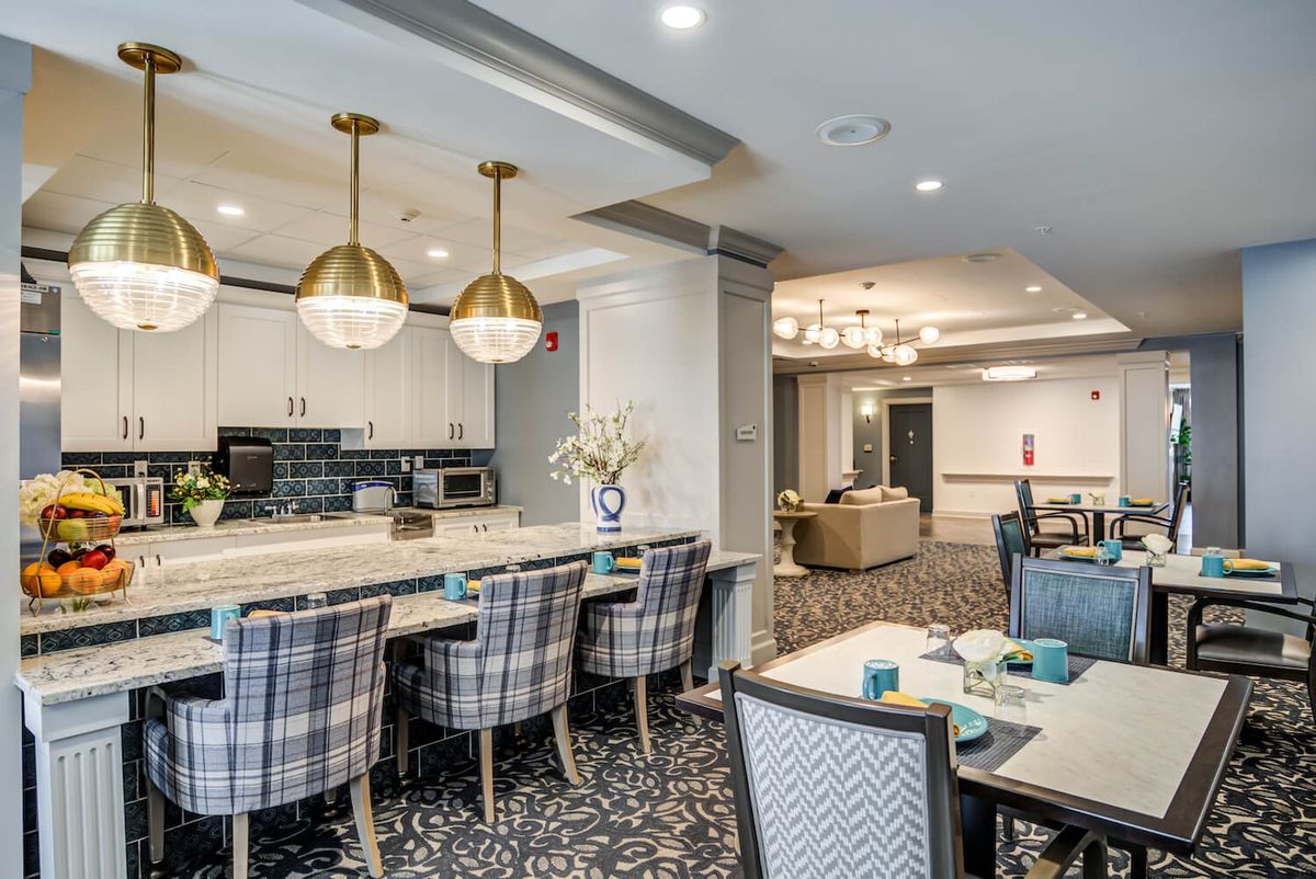 A modern kitchen and dining area with stylish lighting and seating arrangements.