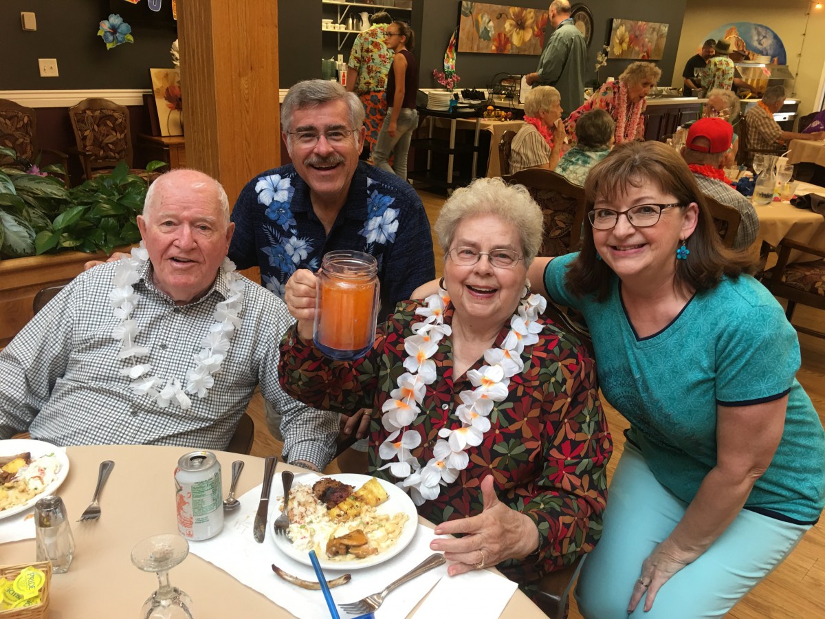A group of seniors celebrating together at a party with food and drinks.