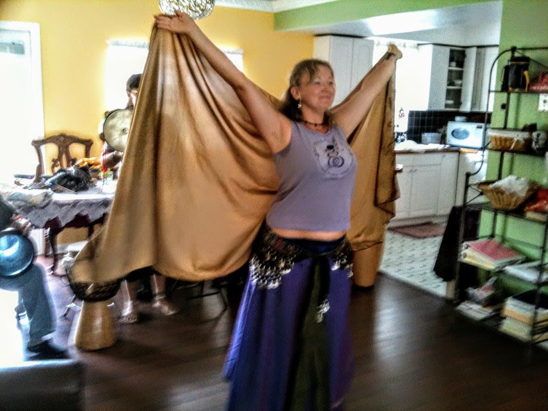 Person practicing a dance with a flowing costume indoors.