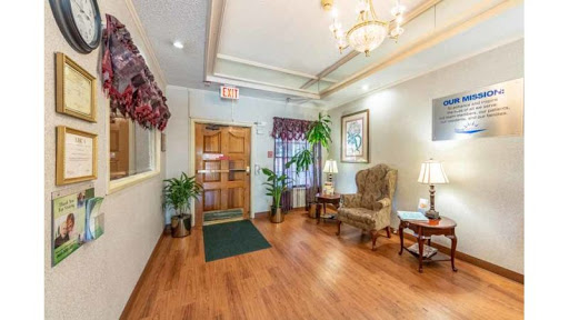 A welcoming lobby featuring wooden flooring, decorative plants, and comfortable seating areas.