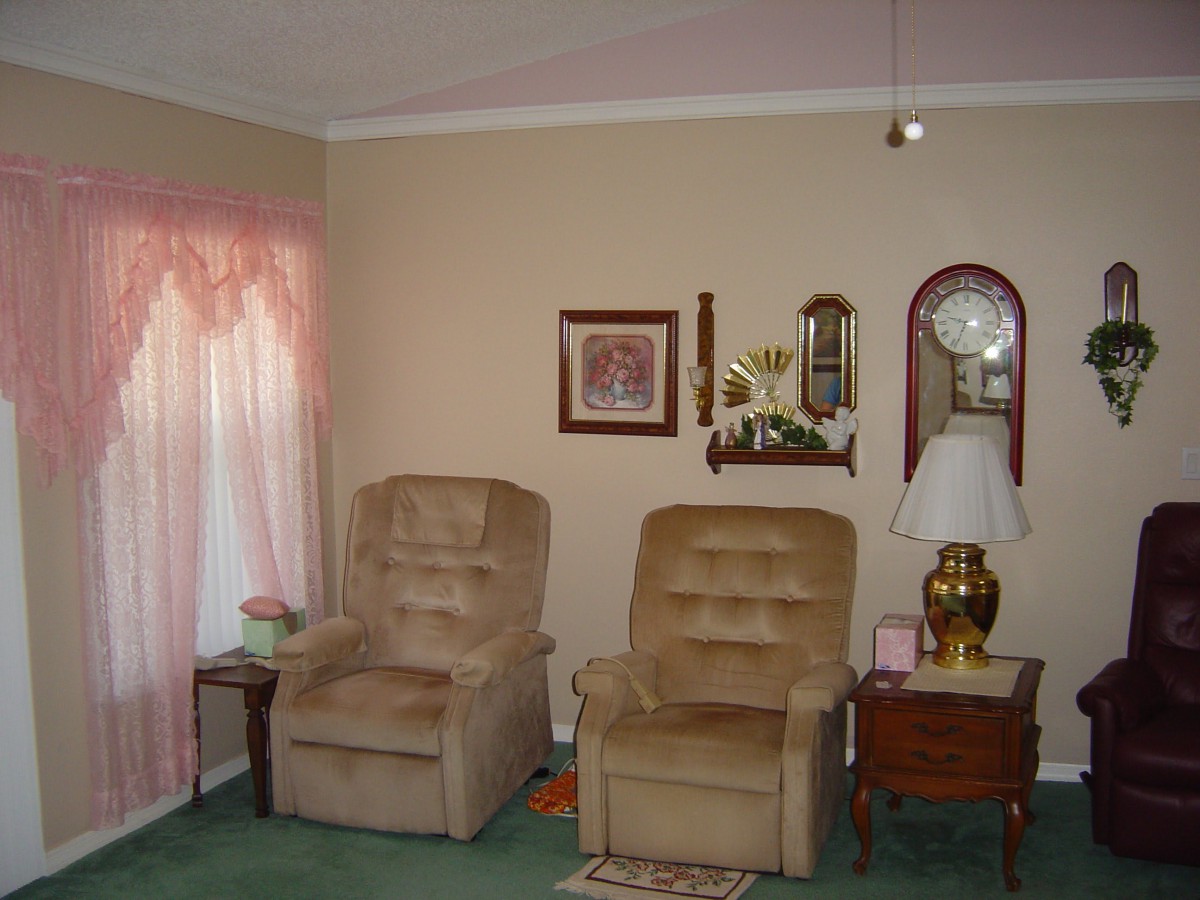 A cozy living room with two recliners, a floor lamp, and decorative wall items.