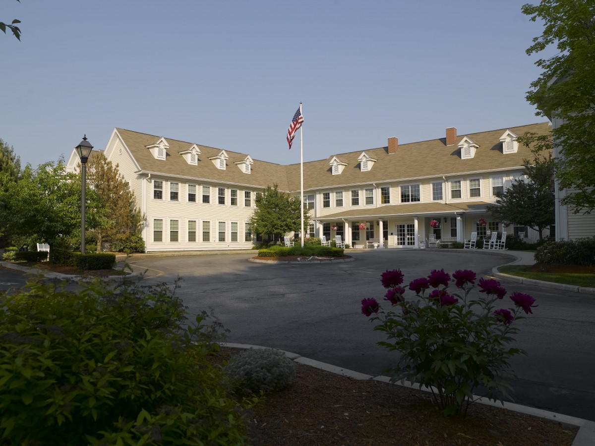 A large building with a U.S. flag in front, surrounded by landscaped greenery.