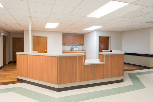 A modern reception area in a healthcare setting, featuring wooden countertops and a clean, organized layout.