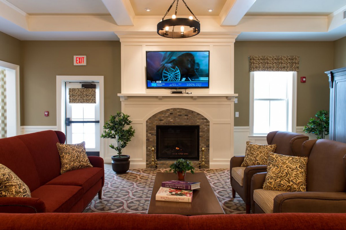 A cozy living room with a fireplace, television, and comfortable seating surrounded by elegant decor.