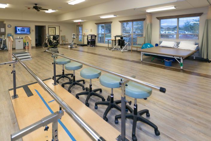 A spacious rehabilitation center equipped with exercise and therapy equipment.