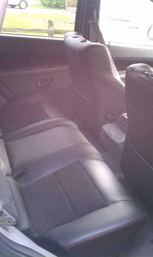 A view of the back seat area inside a car, featuring leather upholstery.