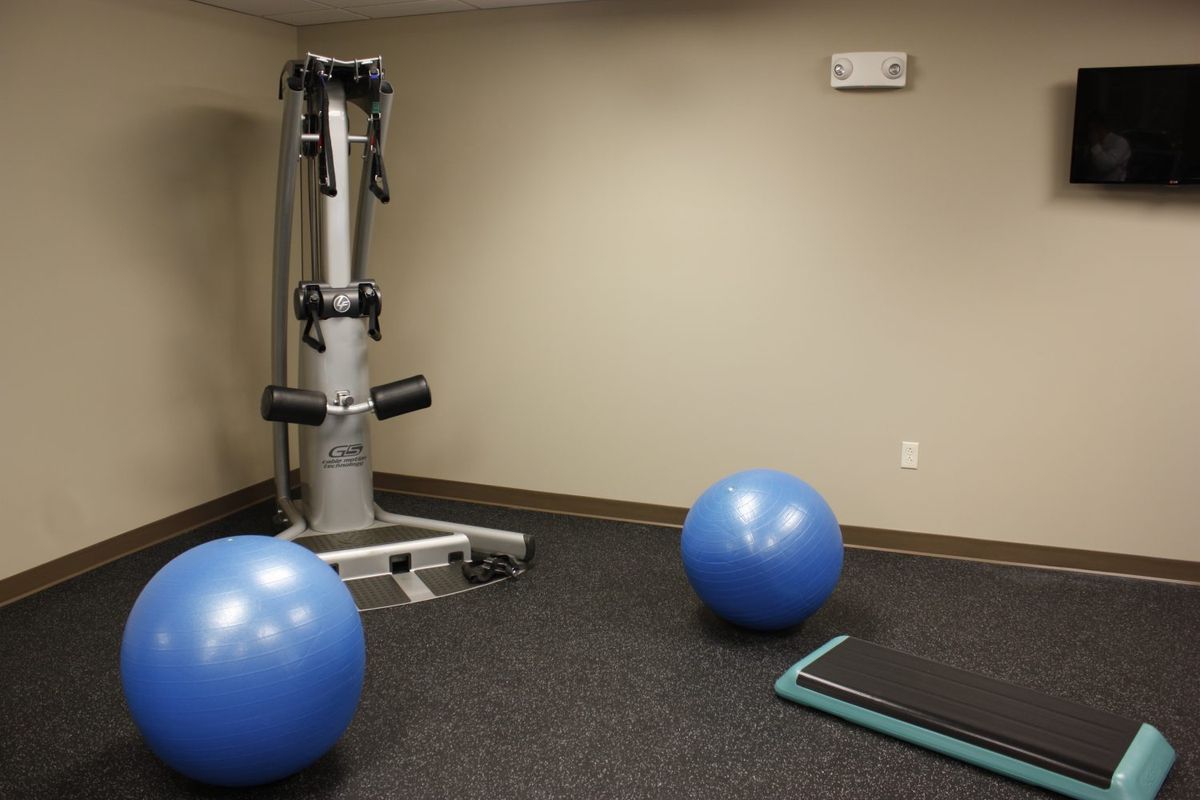 A gym room equipped with balance balls and exercise machines.