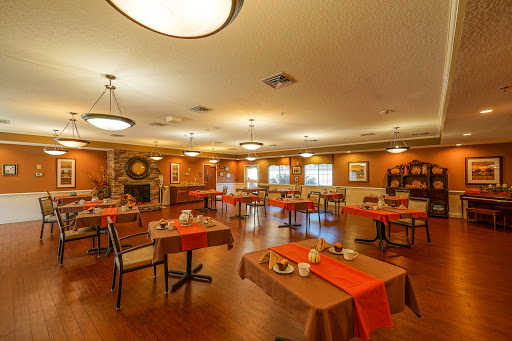 A cozy and inviting dining area with tables set for meals, featuring warm colors and ambient lighting.