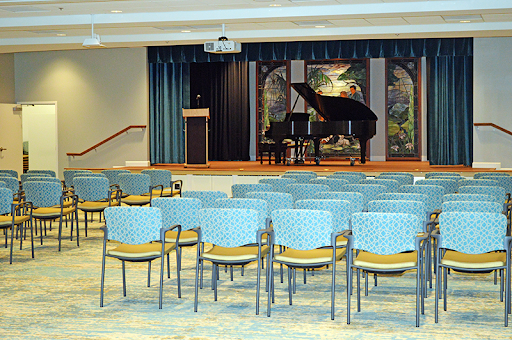 A stage set up for a musical performance featuring a grand piano and seating arrangements for the audience.