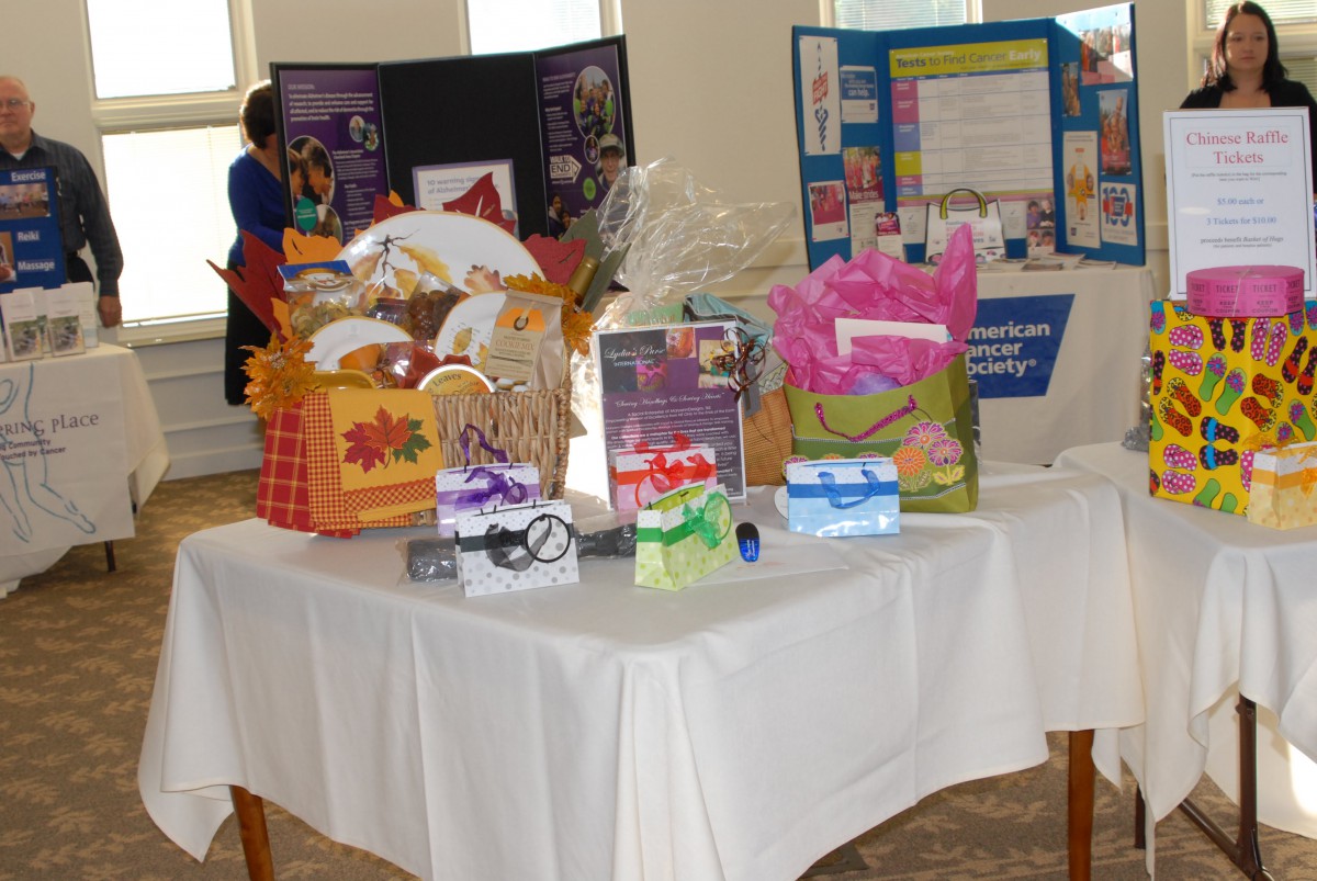 A display table showcasing a variety of gift baskets and raffle items at an event.