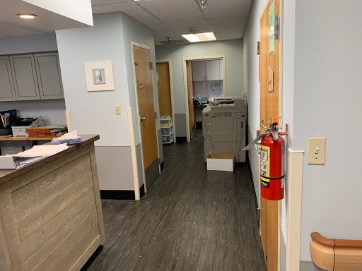 A glimpse into the hallway of a medical office, showcasing the interior design and safety equipment.
