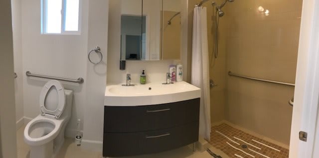 Modern bathroom with a curved vanity and a glass shower enclosure.