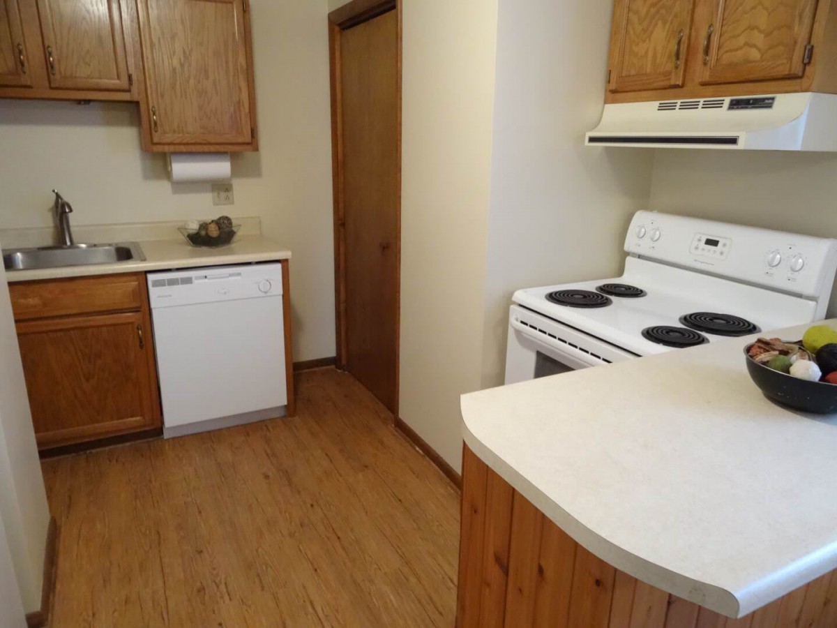 A cozy kitchen with wooden cabinets and modern appliances.
