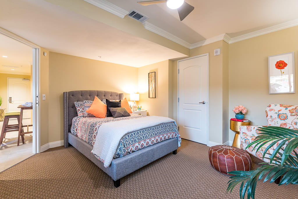 A cozy bedroom with a neatly made bed and warm lighting.