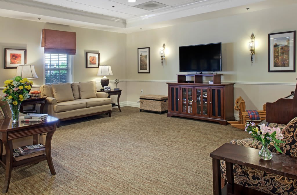 A cozy living room featuring a sofa, television, and framed artwork.