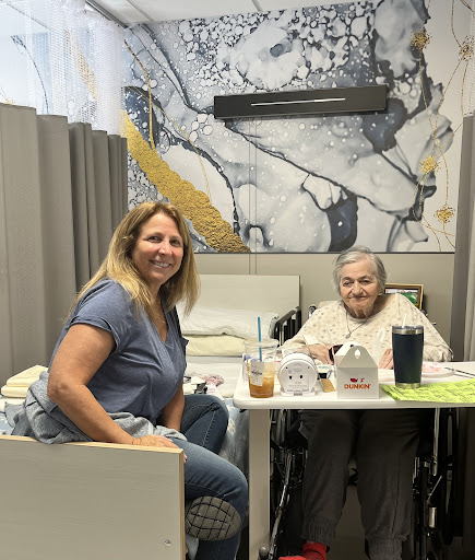 A joyful moment shared between a caregiver and an elderly person in a care facility.