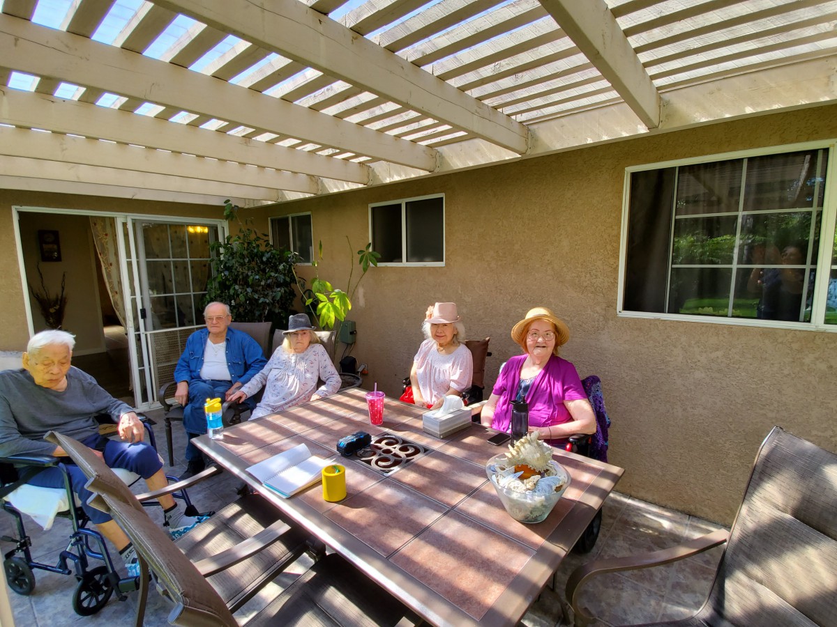 A group of people enjoying a sunny day on the patio.