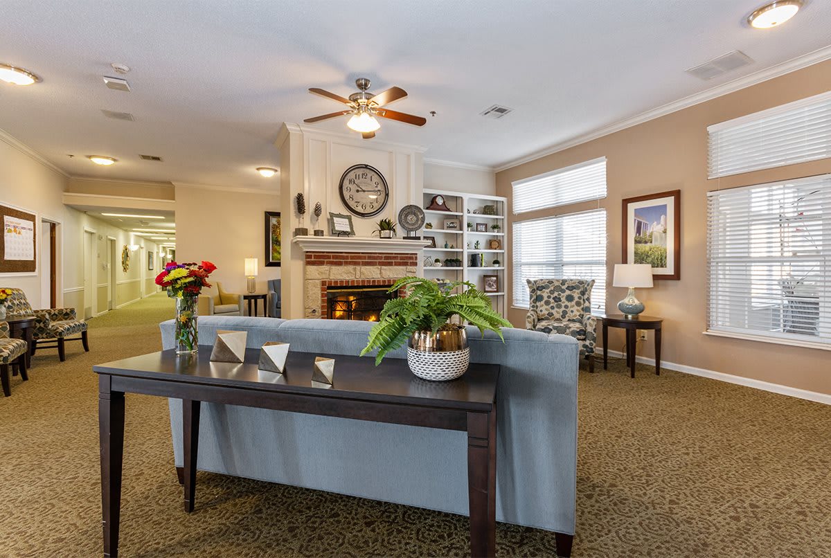 A cozy living room featuring a fireplace, sofa, and decorative elements.