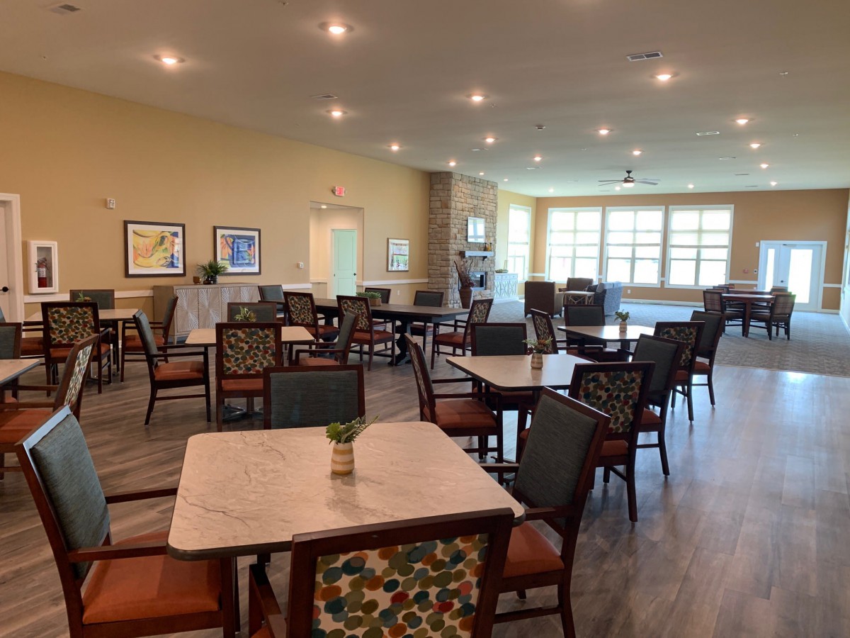 A spacious and well-lit dining room with neatly arranged tables and chairs.