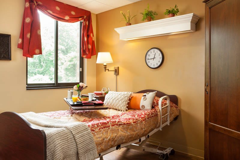 A cozy bedroom with a hospital bed and decorative elements in warm tones.