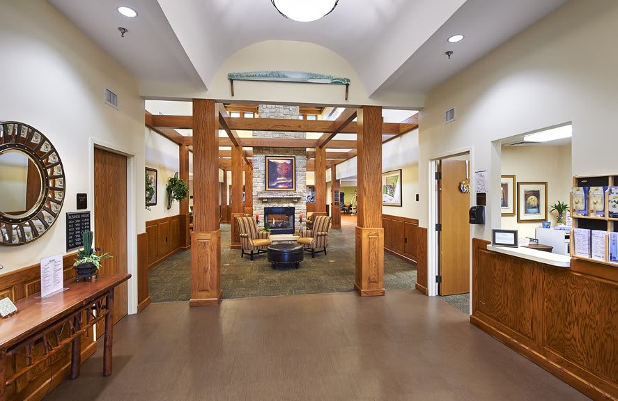 A spacious lobby with wooden beams, comfortable seating, and a central fireplace.