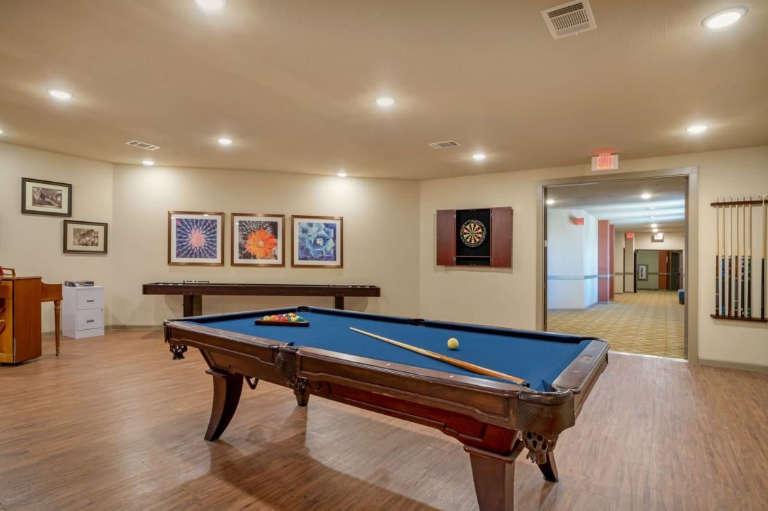 A recreational room featuring a blue pool table and wall art, providing a space for leisure activities.